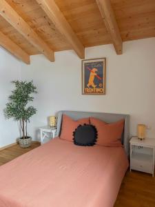 a bedroom with a pink bed and wooden ceilings at Servus Chiemgau - Große Wohnung mit Bergblick in Frasdorf