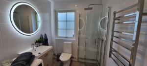 a bathroom with a shower and a sink and a mirror at Apartment in Skogås in Skogås
