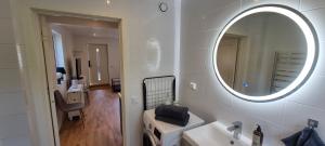 a white bathroom with a mirror and a sink at Apartment in Skogås in Skogås