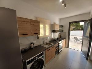 a kitchen with a sink and a washing machine at Velania House 1 in Filótion