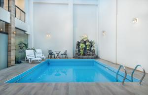 ein Schwimmbad in einem Raum mit Stühlen und einem Tisch in der Unterkunft Hotel Pairumani in Cochabamba