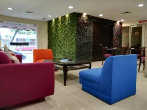 a lobby with colorful chairs and a green wall at Hotel Valgrande in Coatzacoalcos