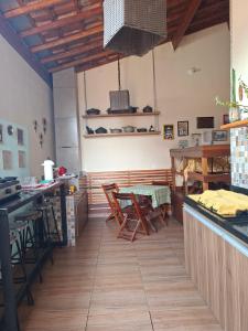 a kitchen with wooden floors and a table and chairs at Suítes da Rô - hospedaria familiar diária e temporada in Varginha +63 photos