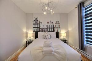 a bedroom with a large white bed with two lamps at Bluenose in Quebec City