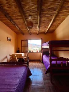 a bedroom with two bunk beds and a window at Casa Mamani in Tilcara +8 photos