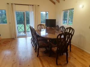 a dining room with a wooden table and chairs at Puyehue in Mantilhue