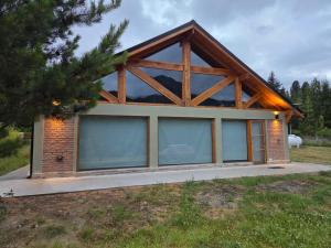 a house with glass windows in a field at Cabaña Cholito in Lago Puelo +7 photos