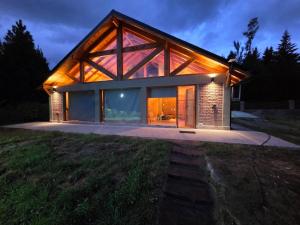 a house with a roof that is lit up at night at Cabaña Cholito in Lago Puelo