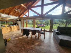 a kitchen and living room with a table and a couch at Cabaña Cholito in Lago Puelo