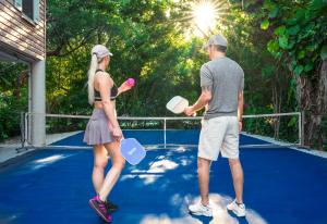 a man and a woman standing on a tennis court at NEW!The HideawayPoolPickleballPutt-PuttKayaks! in Marathon