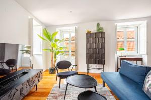 a living room with a blue couch and chairs at Boutique duplex in Chiado with epic Rossio view in Lisbon
