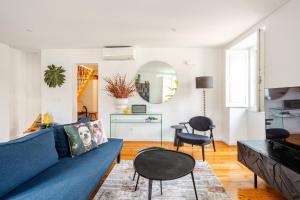 a living room with a blue couch and chairs at Boutique duplex in Chiado with epic Rossio view in Lisbon