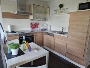 a kitchen with wooden cabinets and a white table at Ferienhaus Marc in Göhren-Lebbin