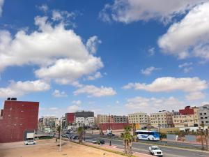 a city with buildings and cars on a street at Residence Almahaj in Laayoune