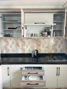 a kitchen with white cabinets and a counter top at Residence Almahaj in Laayoune