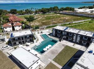 an aerial view of a building with a pool and the ocean at Brisa Mar Prime in Porto Seguro