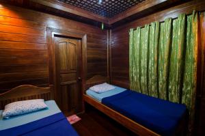 a small room with two beds in a wooden cabin at Pems Pension and Restaurant in Taytay