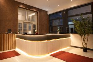 a lobby with a reception desk with lights at Olive INN Berlin in Berlin