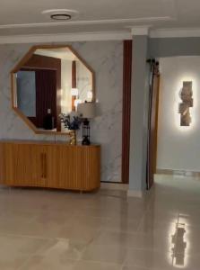 a living room with a mirror and a wooden dresser at Dgomez House in Santiago de los Caballeros