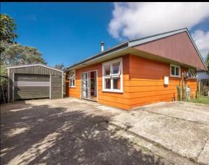 a small house with a garage in front of it at Beachy Sounds House in Carters Beach