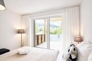 ein Schlafzimmer mit einem Bett und einem großen Fenster in der Unterkunft Apartment Frida by Da Alois in Gröbming