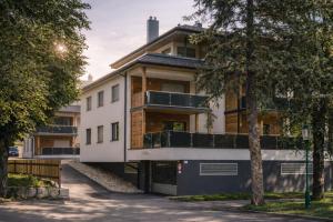 ein Mehrfamilienhaus mit Balkonen und einem Baum in der Unterkunft Apartment Frida by Da Alois in Gröbming