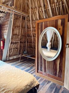 a room with a round mirror in a straw hut at Chavez Eco Beach Camping and Cabañas in Tulum