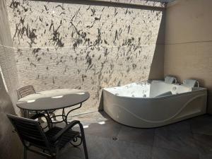 a bathroom with a tub and a table and a chair at Finca Hotel Casa Bela in Santa Fe de Antioquia