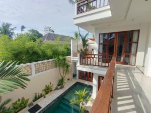 a house with a swimming pool and a balcony at Artha Sadia Villa 2 Seseh Beach in Cemagi