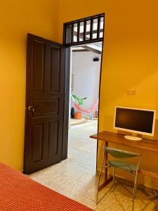a room with a desk with a computer and a door at Casa Tierra Libre in Cali