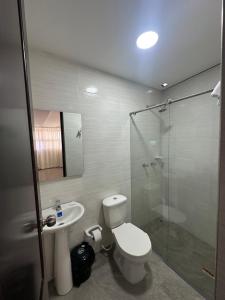 a bathroom with a toilet and a glass shower at Hotel vizion in Ibagué