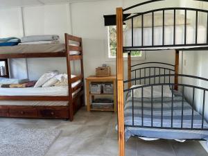 a room with two bunk beds and a table at Blue Horizon Hideaway in Matapouri