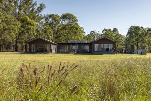 a house in the middle of a field at Wallaby Lodges in Pokolbin