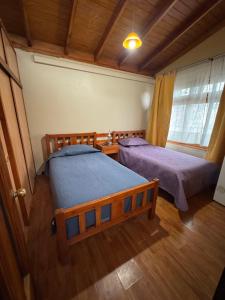a bedroom with two beds and a window at Hostal Asuncion in Arica