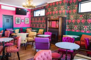 a room with colorful chairs and tables in a restaurant at Metropolitan Hotel in Orange