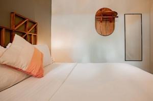 a bedroom with a large white bed and a mirror at Selina Venao Beach West in Playa Venao