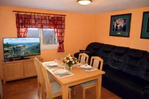 a living room with a table and a television at Chata Adrian Slovak Paradise in Spišské Tomášovce