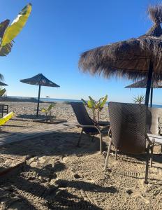 a beach with chairs and umbrellas and the ocean at Bega's BDuplex in Golem, Durrës in Golem