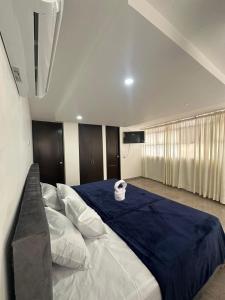 a bedroom with a large bed with a blue blanket at Hotel vizion in Ibagué