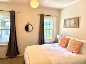 a bedroom with a bed and two windows at Cozy Farm House with River access in Three Rivers