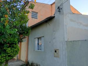 a white building with a window and a tree at Casa sobrado in Alegrete