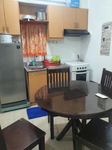 a small kitchen with a table and a refrigerator at Palmetto condominium in Davao City