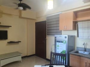 a small kitchen with a refrigerator and a sink at Palmetto condominium in Davao City