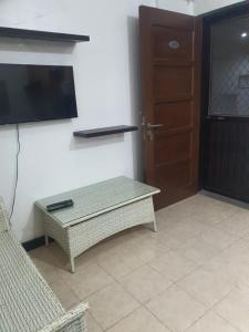 a living room with a table and a tv and a door at Palmetto condominium in Davao City