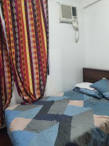 a bedroom with a bed with a blanket on it at Palmetto condominium in Davao City