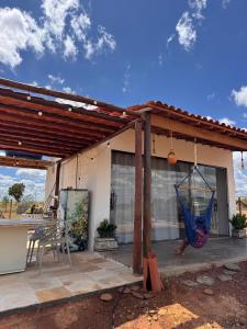 a patio with a hammock hanging from a house at Chalé Mansões do Rio in Casa Nova