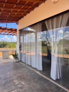 a patio with sliding glass doors with a view at Chalé Mansões do Rio in Casa Nova +5 photos