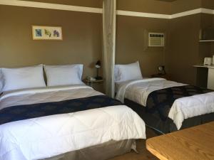 a hotel room with two beds with white sheets at Motel Montgolfière JP in Saint-Jean-sur-Richelieu