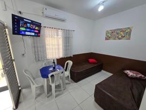 a living room with a couch and a table with chairs at Pousada Mar e Luz in Ilha Comprida