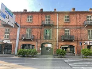 a large red brick building with a green door at Bon Bon del Corso con terrazzo e aria condizionata in Asti